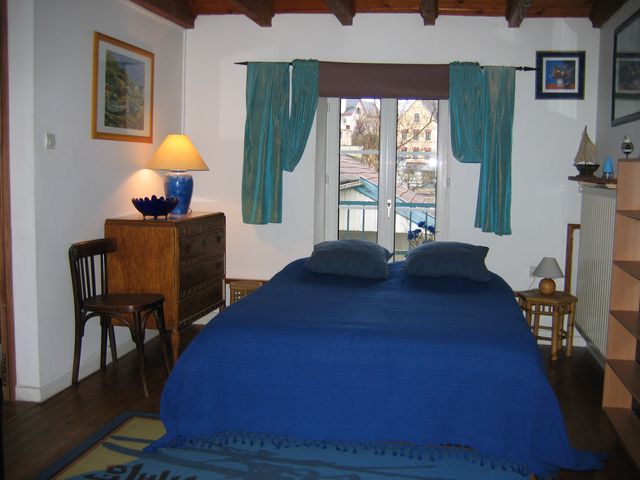 The first bedroom with 1 double bed and a low armless chair.